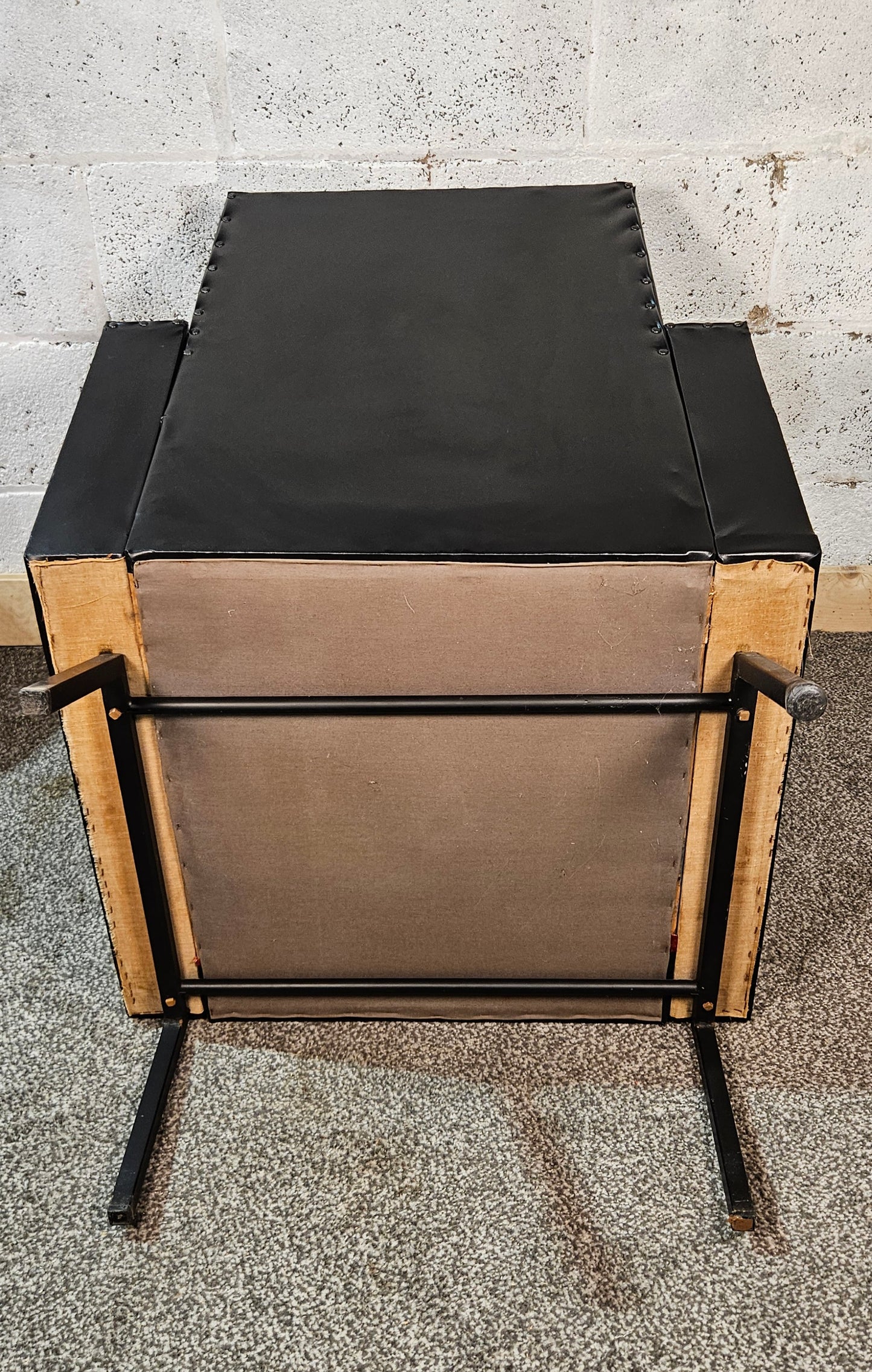 Faux leather Black lounge chair with red seat pad.