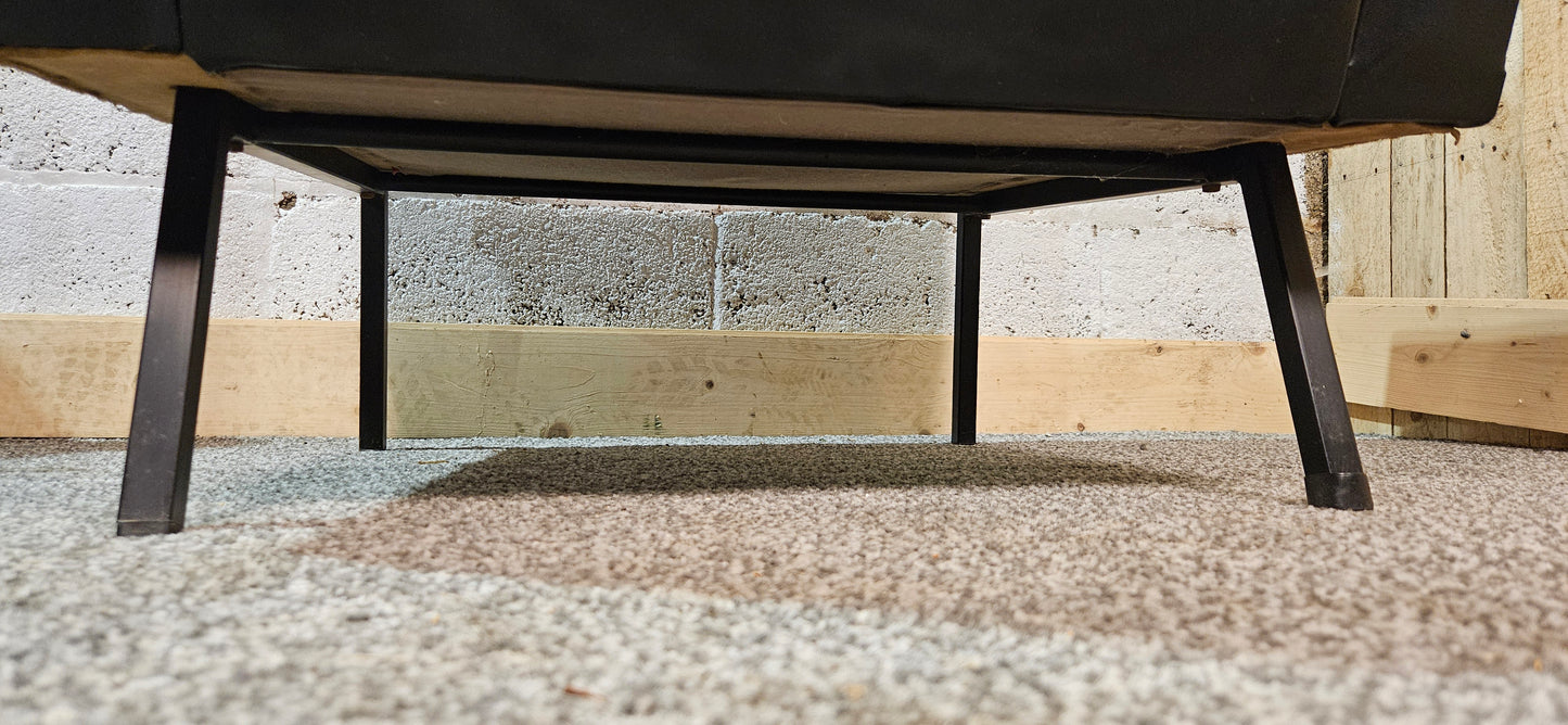 Faux leather Black lounge chair with red seat pad.