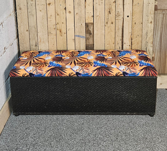 Black wicker style ottoman/storage with re upholstered top.